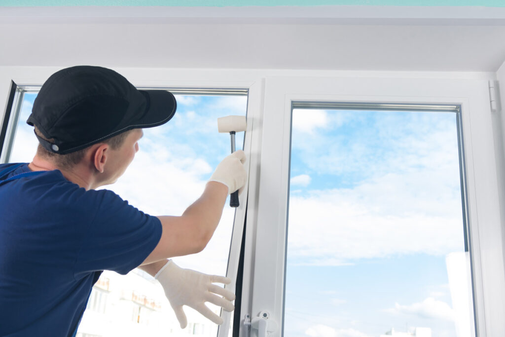 A person with a black hat installing energy efficient windows in El Paso.
