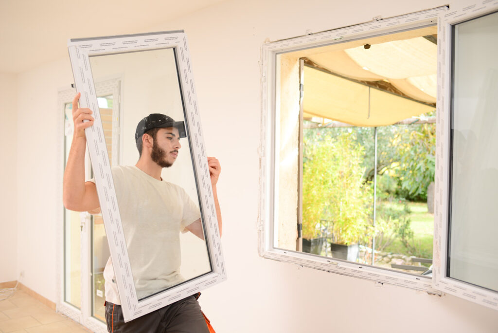 A person installing replacement windows in an El Paso home.